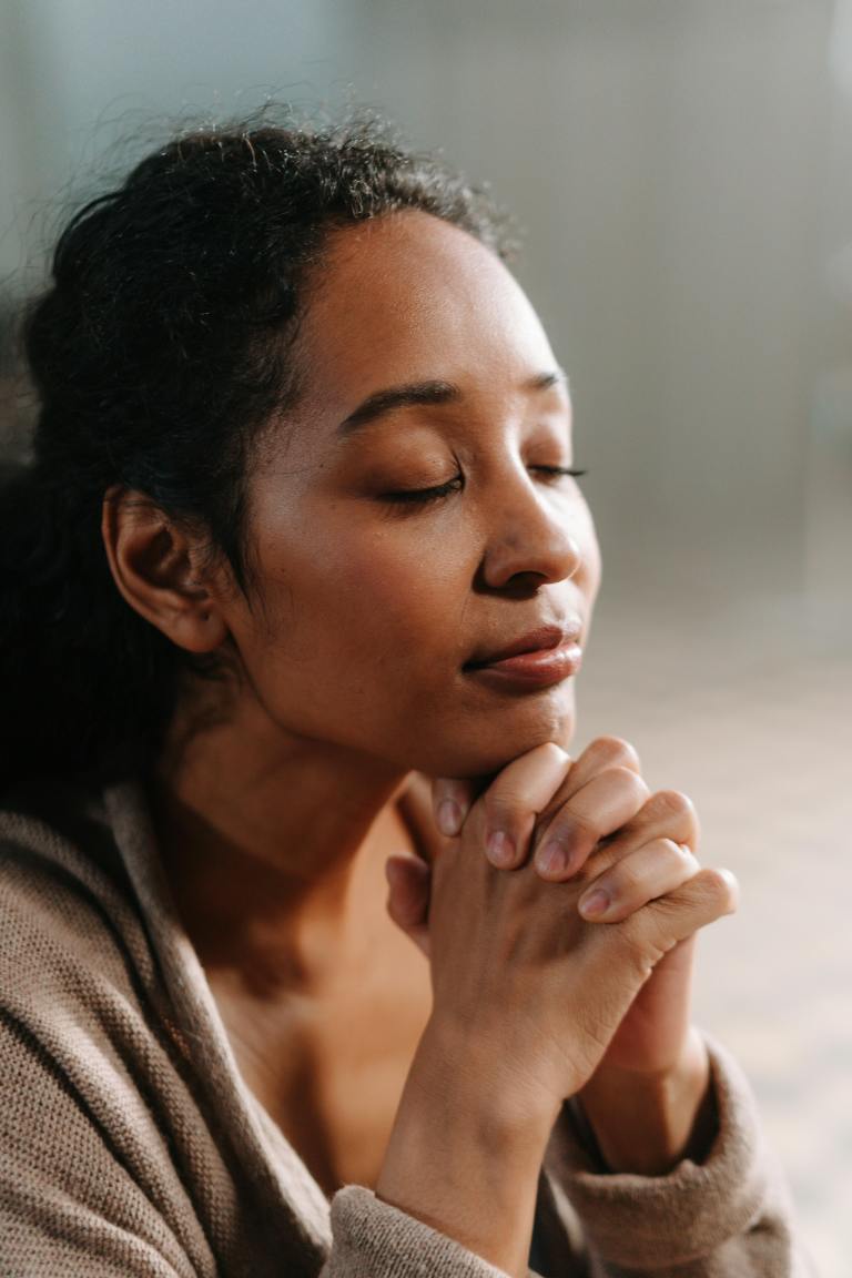 Woman praying quietly for emotional wellbeing and mind renewal with Scripture, renew the mind